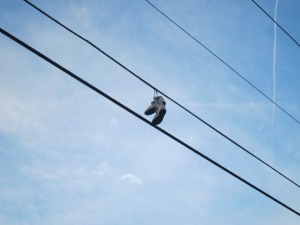 A pair of sneakers hanging off an elictrical wire.  Goodness knows how they got there!